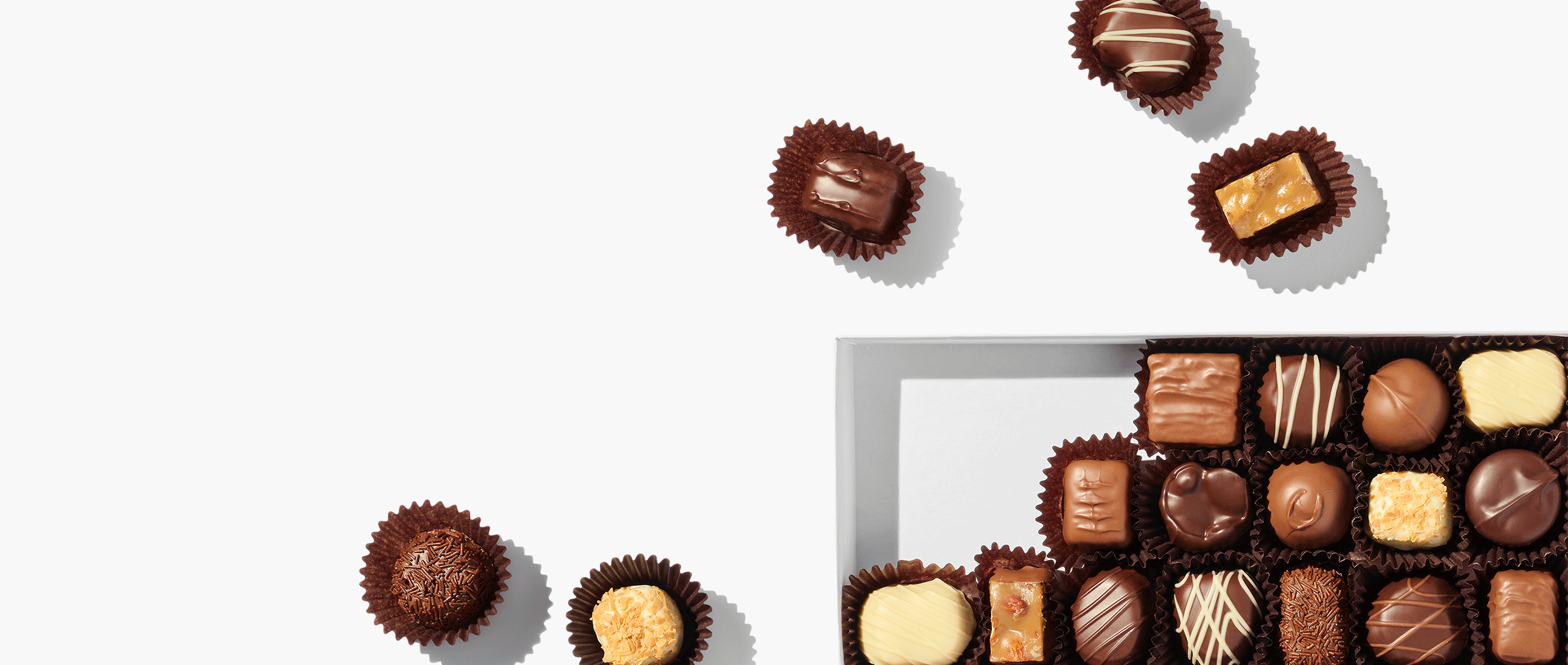 A rotation showing a box of chocolates, a box of lollypops and a heart-shaped box of chocolates